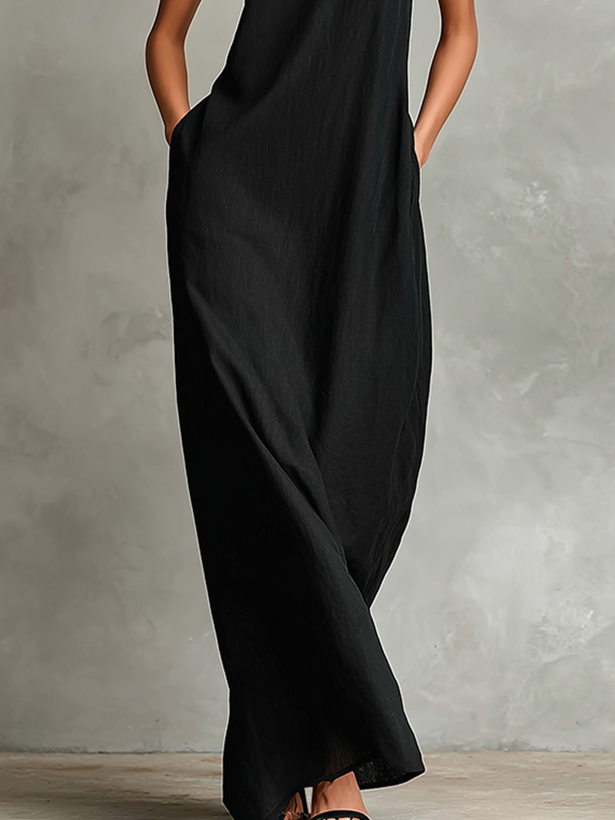 Detalle de los bolsillos laterales de costura del vestido negro Caterina, con la mano dentro