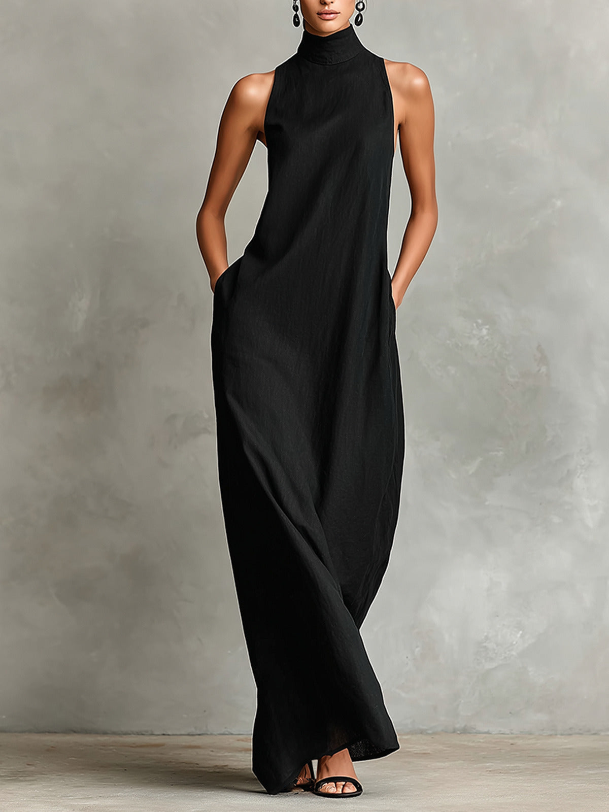Vestido negro Caterina de cuerpo entero, con las manos en los bolsillos