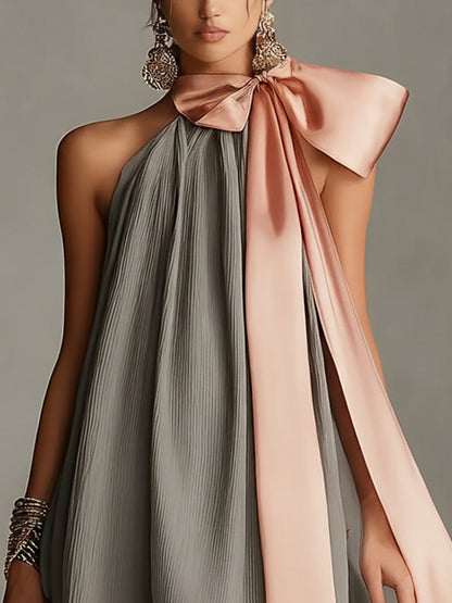 Vestido gris plisado con lazo rosa y ribete de encaje vista frontal
