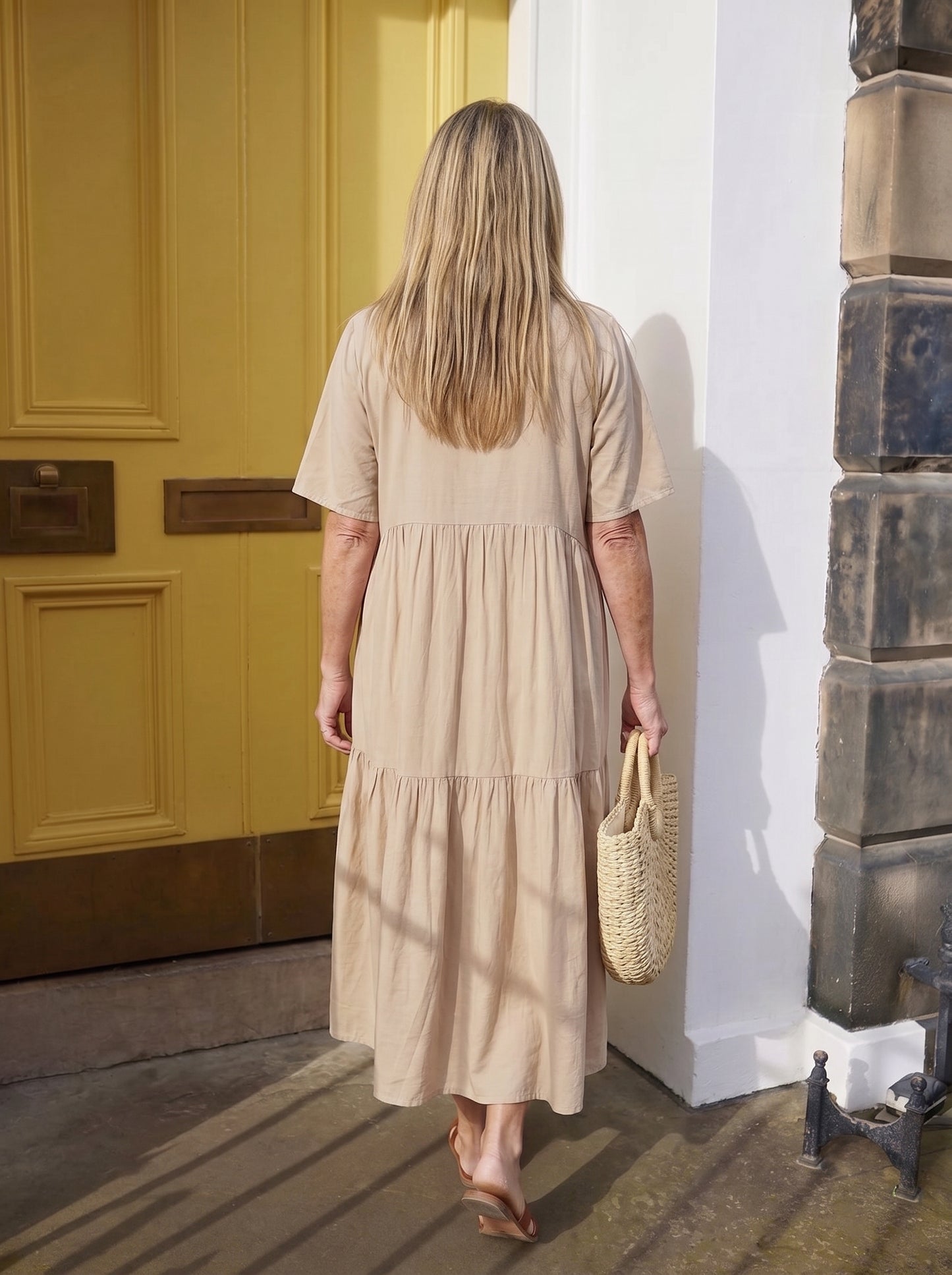 Vestido Alba beige de espalda, la tela cae recta desde los hombros