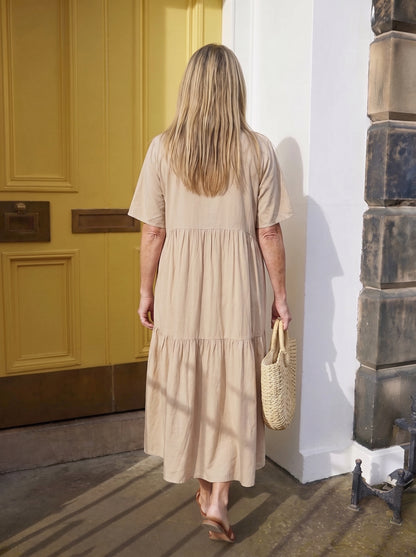 Vestido Alba beige de espalda, la tela cae recta desde los hombros
