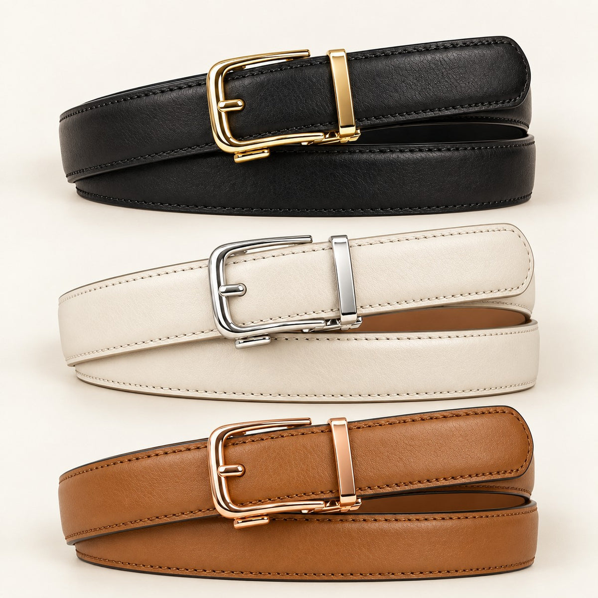 Tres Cinturones Clásicos apilados: negro con hebilla dorada, blanco con plateada y camel con oro rosa