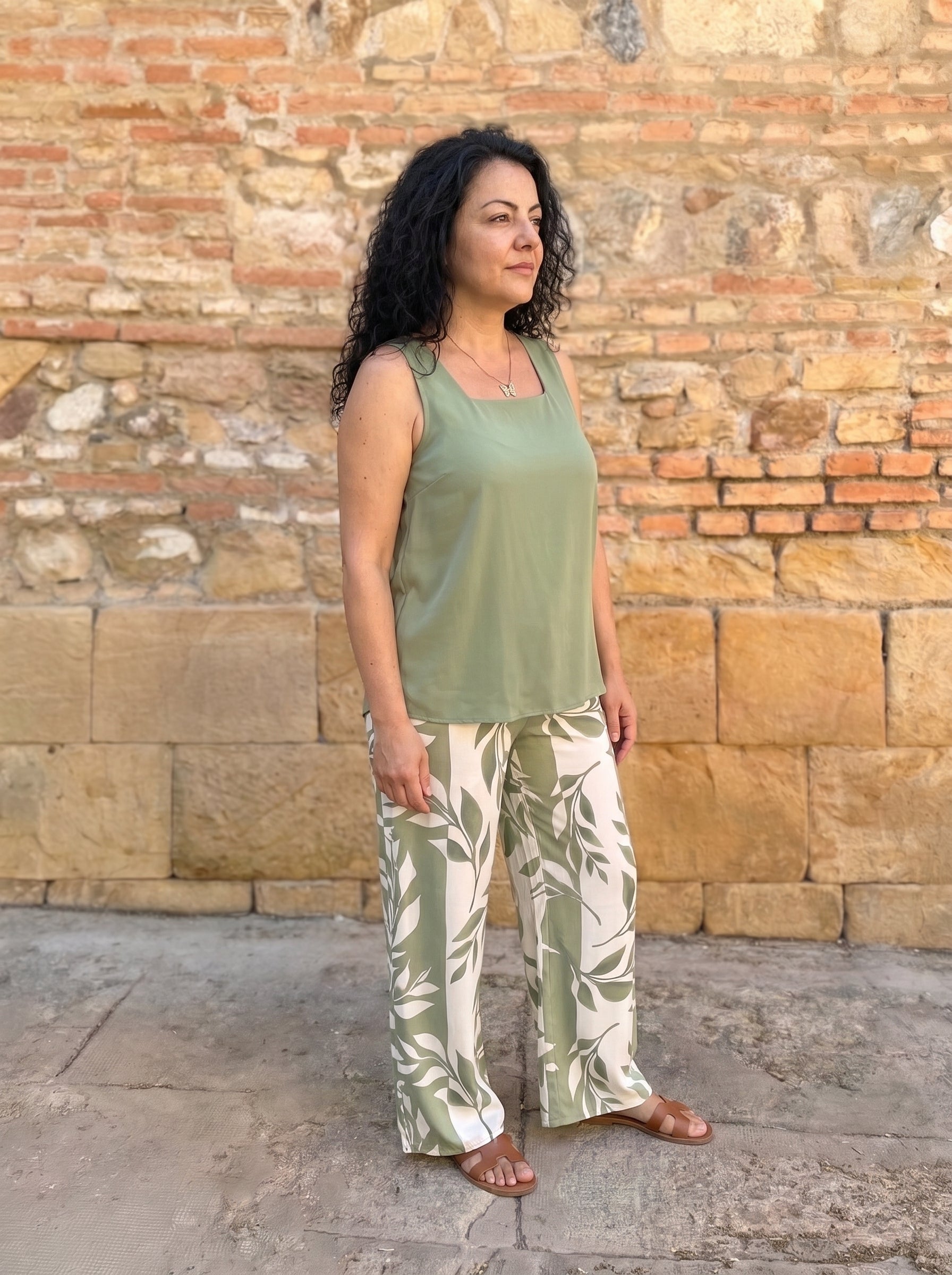 Conjunto fluido en verde de tres cuartos, se ve la caída del pantalón