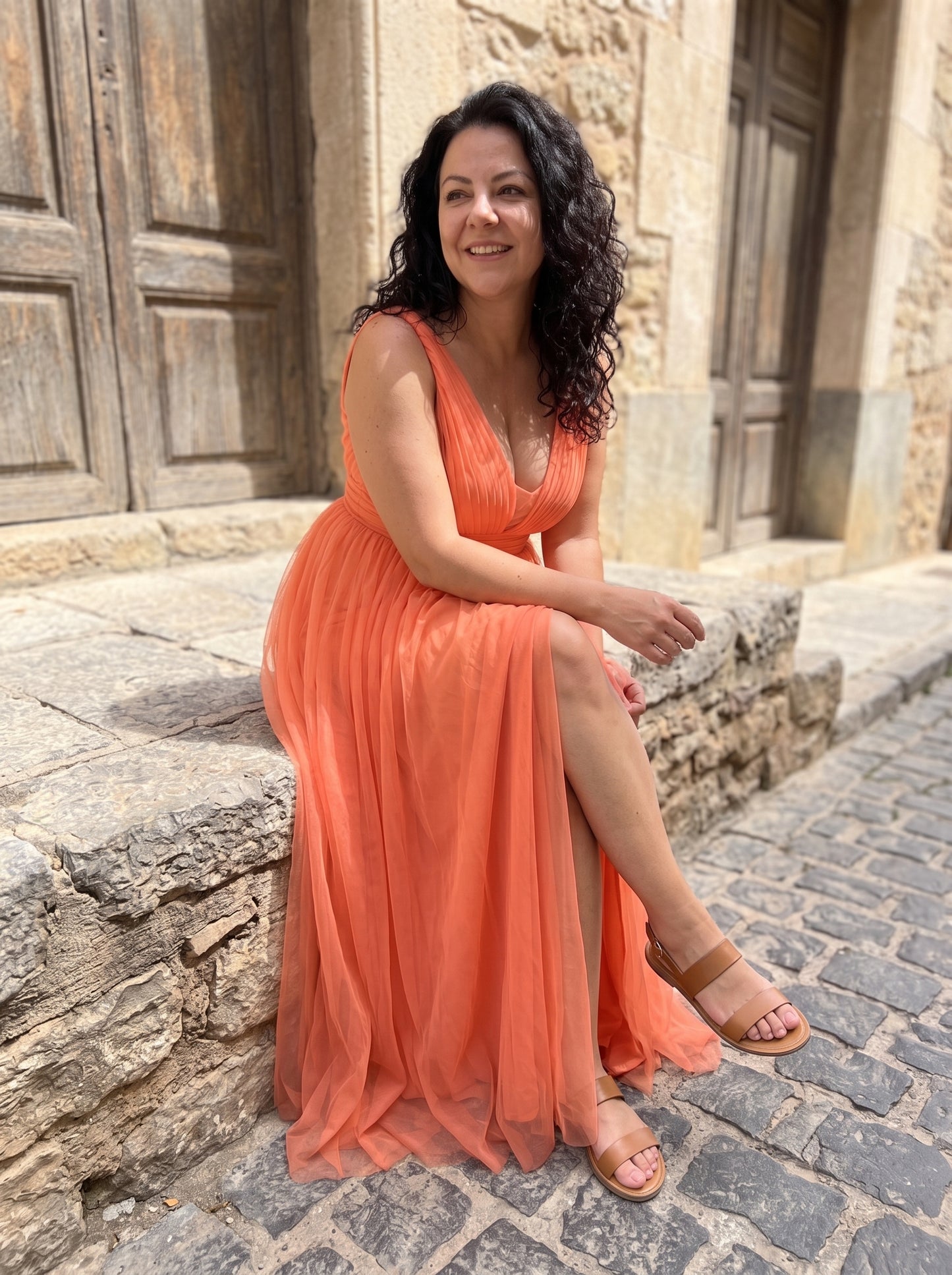 Mujer sentada con el maxi vestido Ginevra coral, comodo tambien sentada