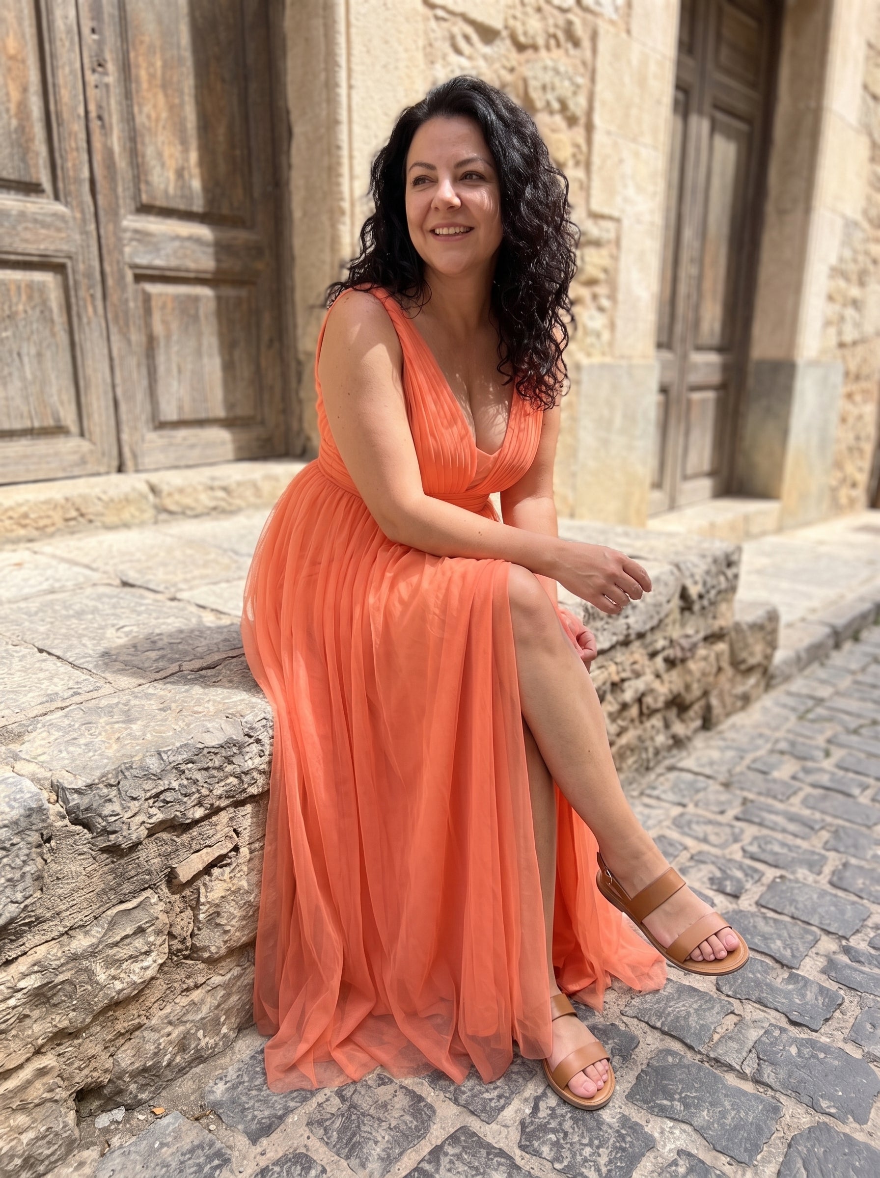 Mujer sentada con el maxi vestido Ginevra coral, comodo tambien sentada