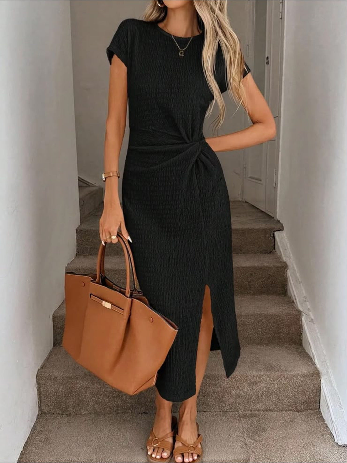Vestido midi Julia en negro con la abertura frontal abierta al caminar