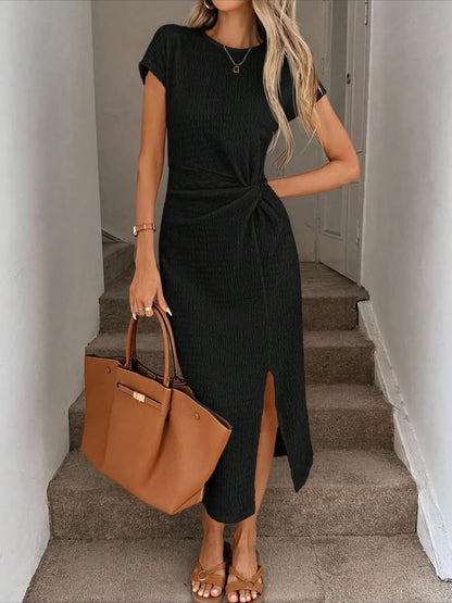 Vestido midi Julia en negro con la abertura frontal abierta al caminar