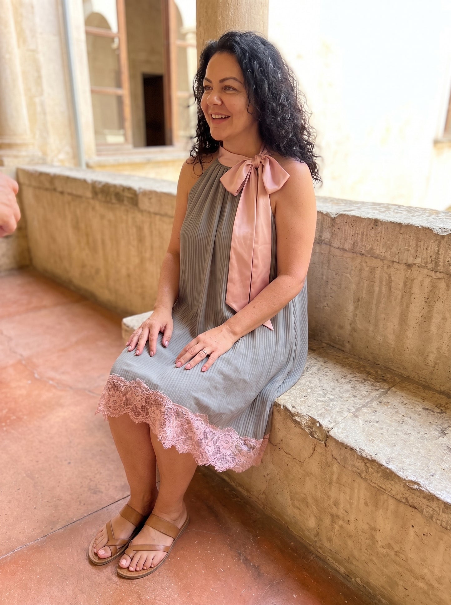 Mujer sentada con el minivestido gris plisado