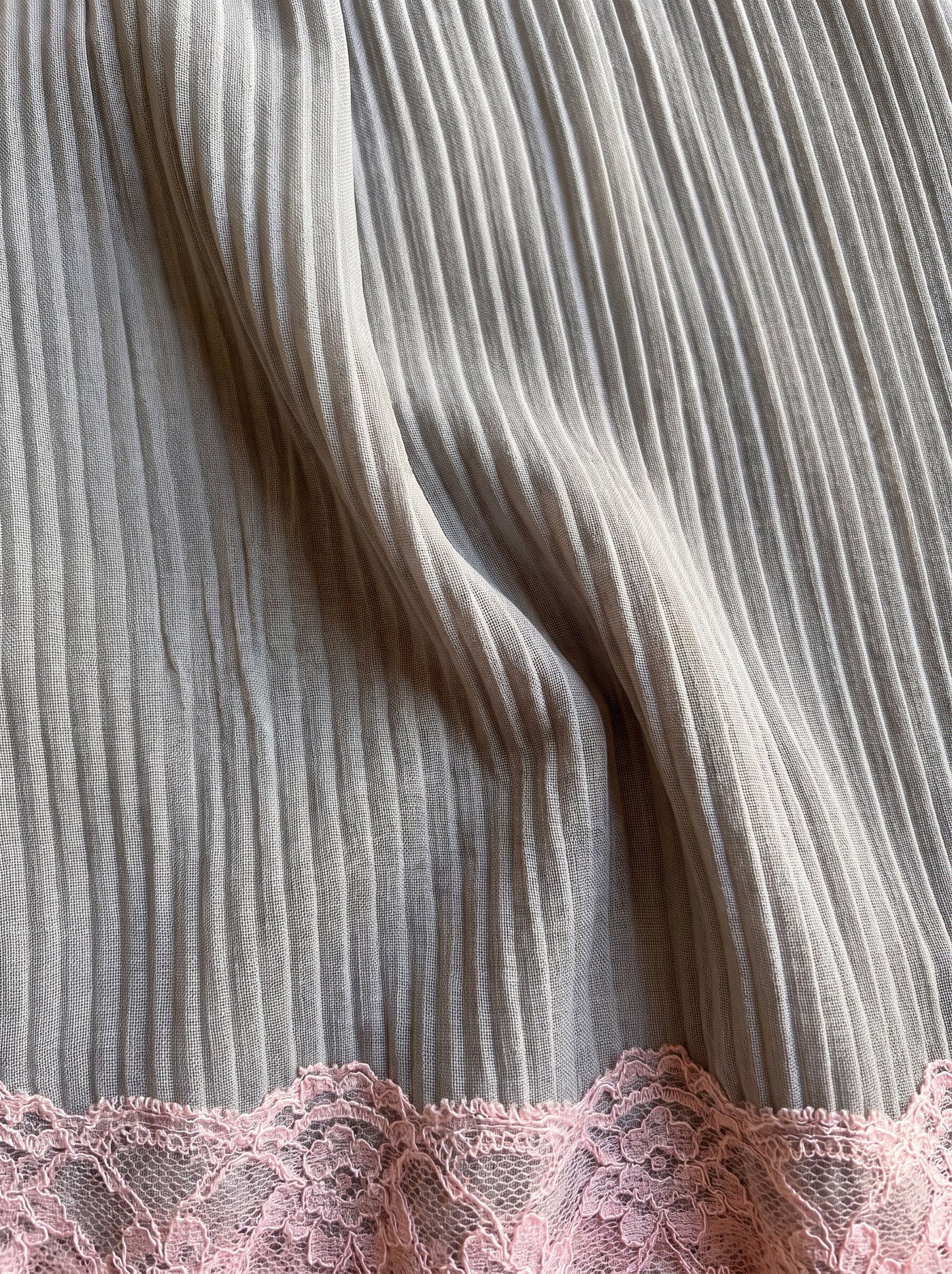 Detalle del plisado y el encaje rosa del minivestido