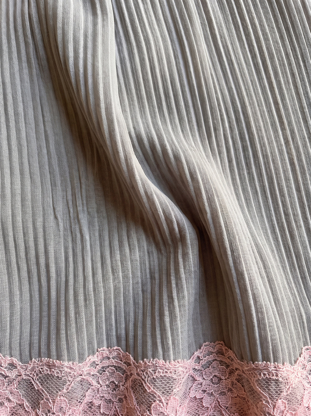 Detalle del plisado y el encaje rosa del minivestido