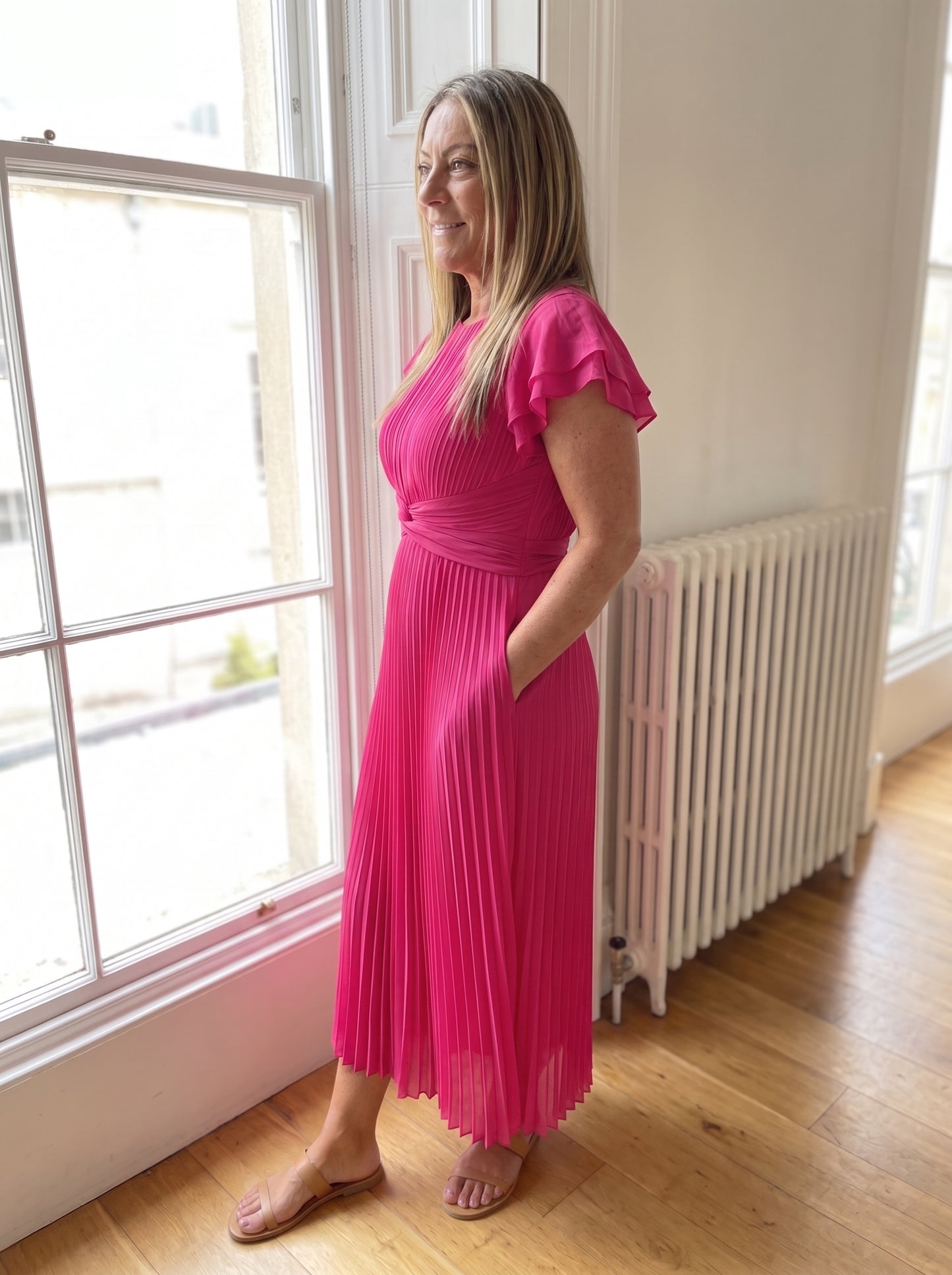 Vestido Seraphina en rosa de tres cuartos, se ve la caída del plisado