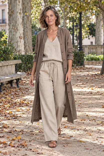 Valentina en beige con el sobretodo abierto, paseando por un parque en otoño