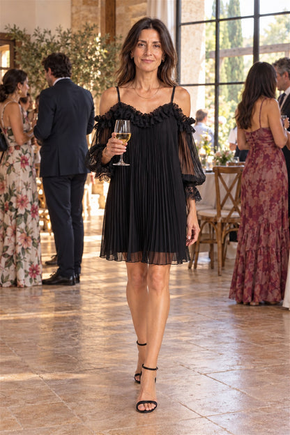 Vittoria en negro, de invitada en el salón de una finca con una copa en la mano