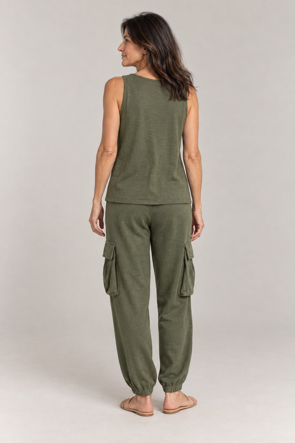 Adriana en verde oliva, foto de estudio de espaldas: top sin mangas y pantalón con bolsillos laterales