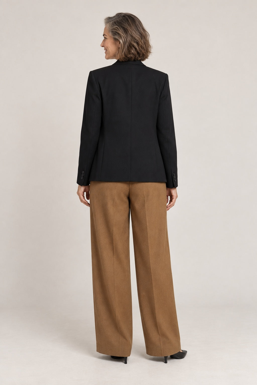 Pantalón de pierna ancha marrón tabaco, foto de estudio de espaldas con blazer negra