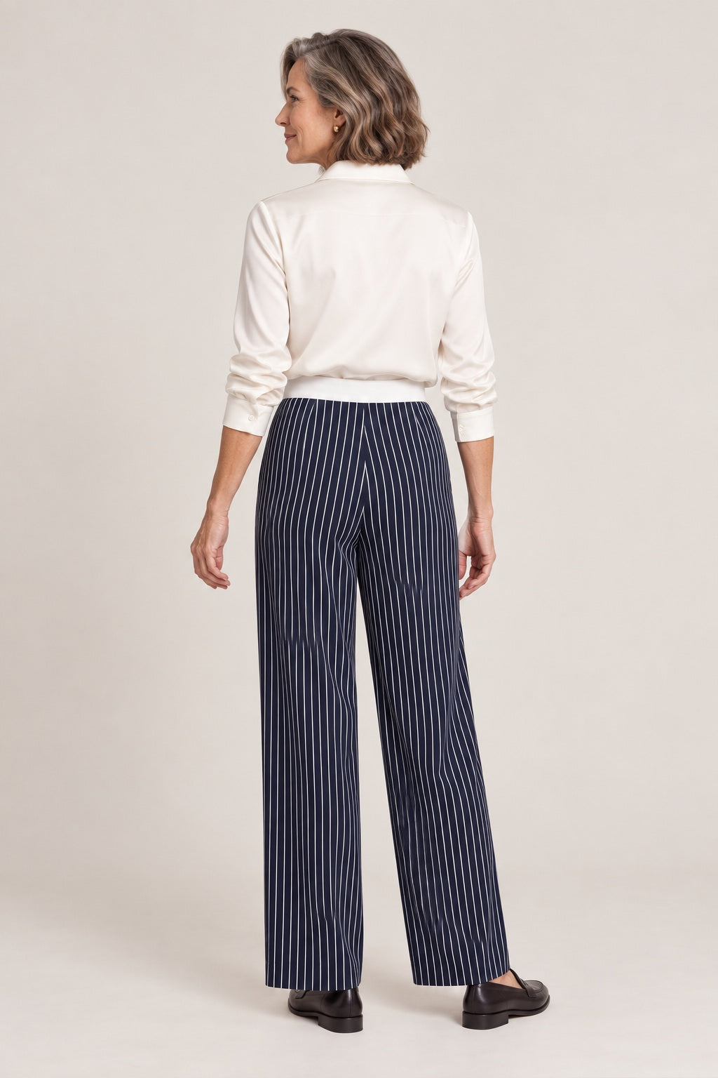 Pantalón de rayas verticales azul marino, foto de estudio de espaldas con camisa crema