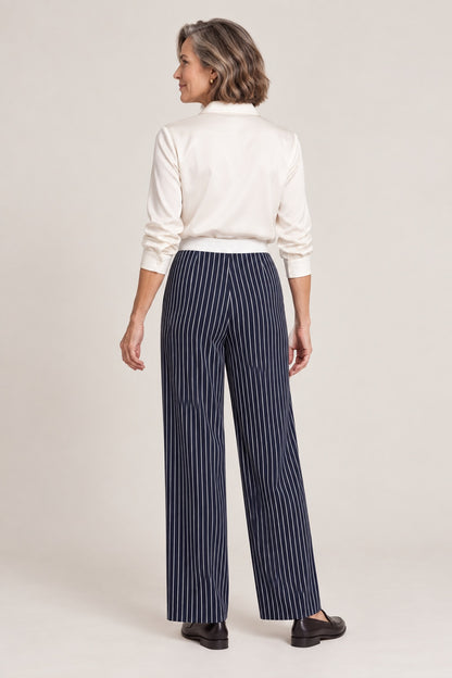 Pantalón de rayas verticales azul marino, foto de estudio de espaldas con camisa crema