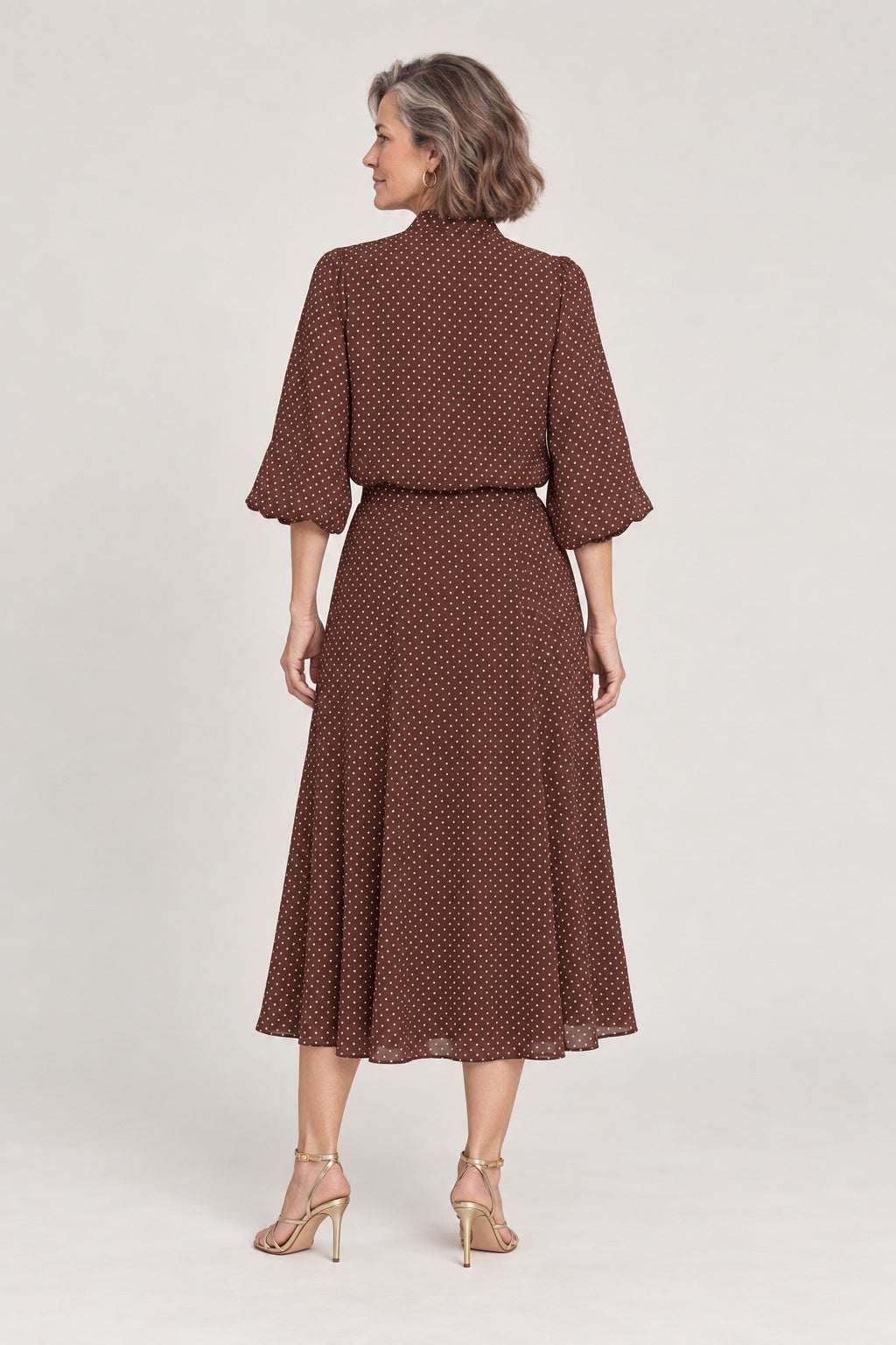 Rocío en marrón de lunares, foto de estudio de espaldas: blusa y falda midi con vuelo