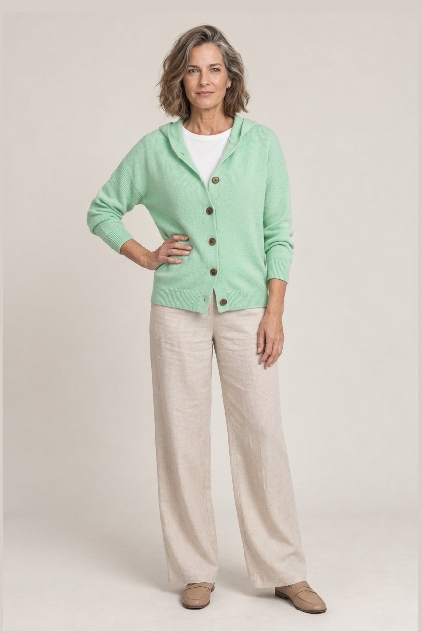 Chaqueta de punto con capucha y botones de madera en verde menta, foto de estudio de frente